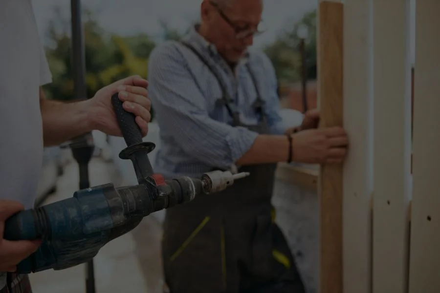 two workers installing wooden fence